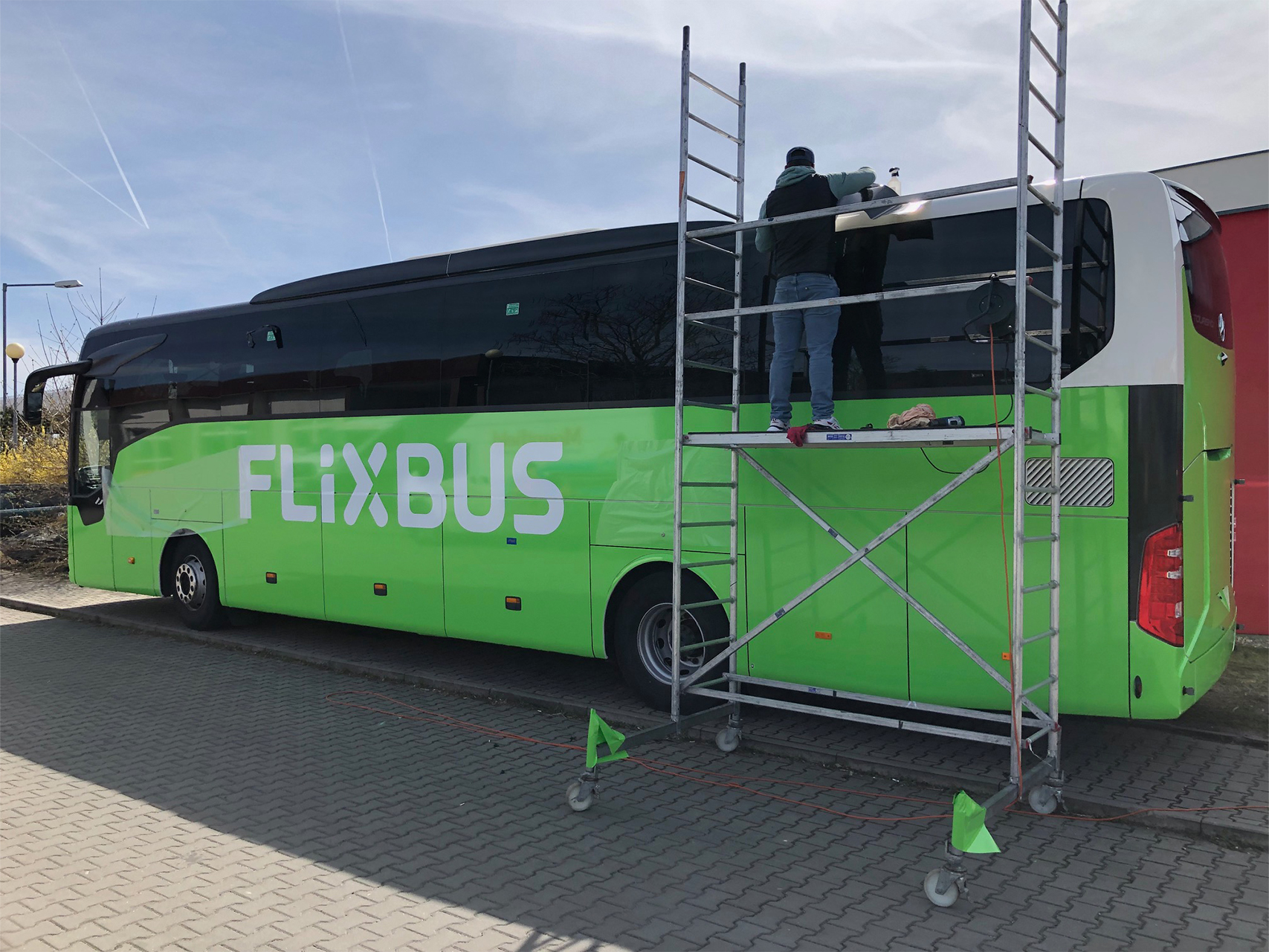 Aplikace reklamního polepu firemního autobusu společnosti Flixbus